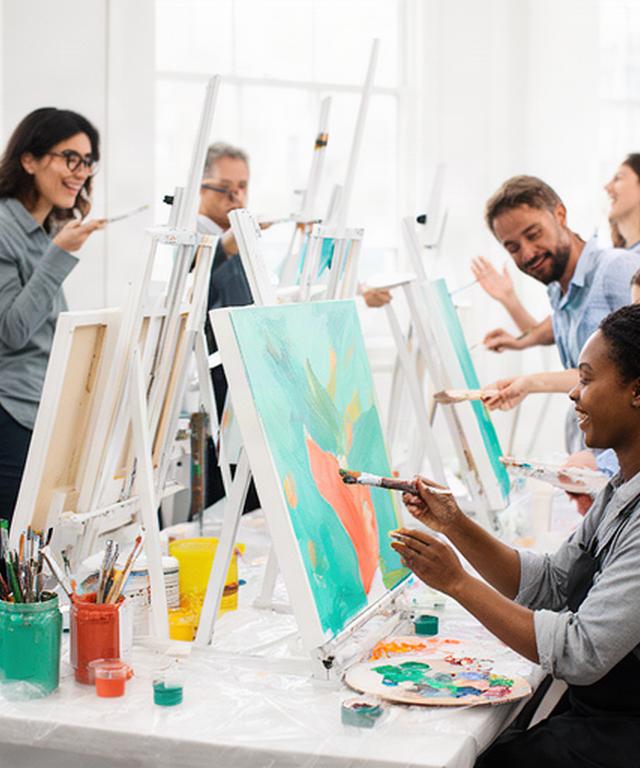 Colleagues painting at easels together in a bright Dublin studio