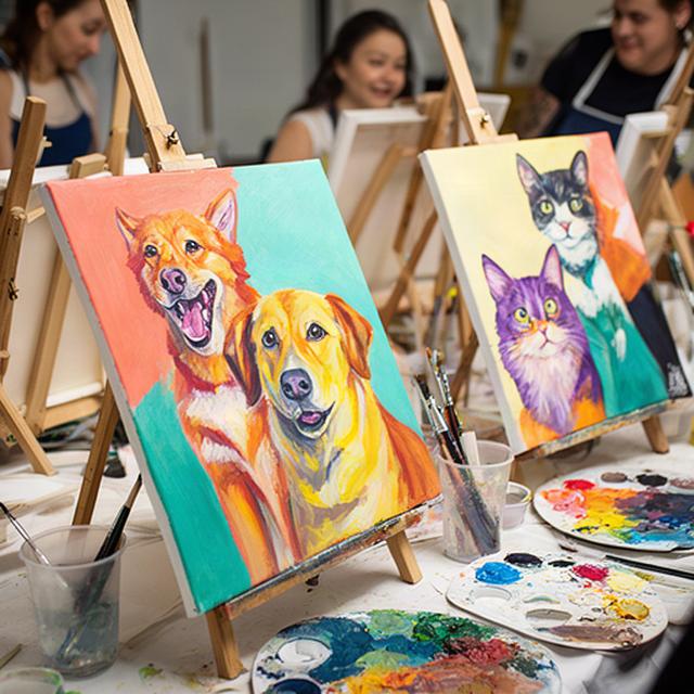 Bright painted pet portraits displayed on easels during a Dublin social art night